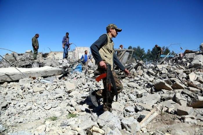Fighters from the Kurdish People's Protection Units (YPG) visit the site of Turkish airstrikes near northeastern Syrian Kurdish town of Al-Malikiyah on April 25, 2017