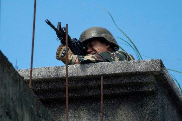A Philippine soldier takes aim at militant positions from a rooftop in Marawi on June 13, 2017