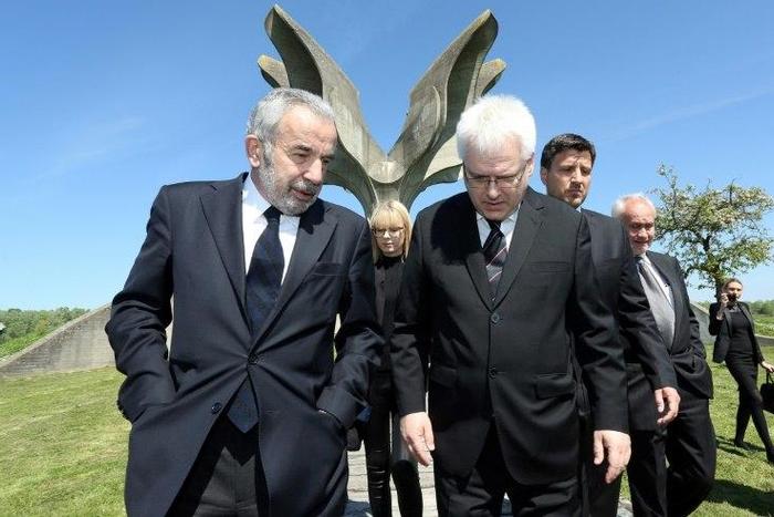 Coordinator of the Jewish communities in Croatia Ognjen Kraus (L) and Croatian rabbi of the Jewish community Luciano Mose Prelevic (R) walk in front of a memorial in the shape of a flower in Jasenovac on April 15, 2016