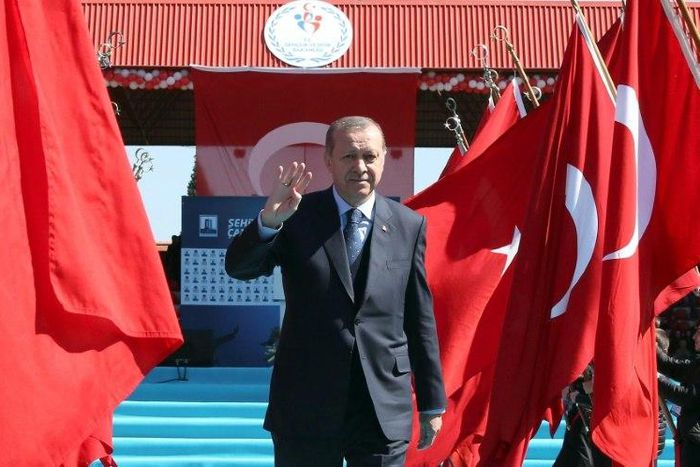 Turkish President Recep Tayyip Erdogan waves as he arrives to attend a ceremony marking the 102nd anniversary of the Canakkale Victory