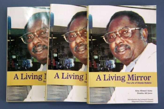 Two fugitive former army officers have been indicted over the 2004 murder of prominent Gambian journalist Deyda Hydara, shown here on the cover of a book on his life