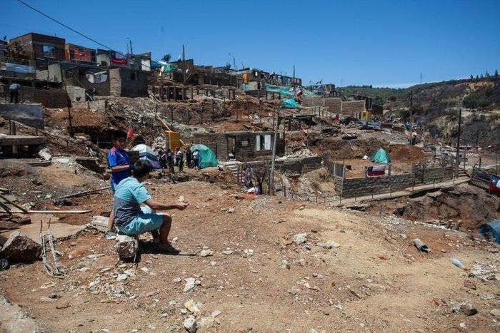 Local residents live in tents while they work to rebuild after the damage caused by the January 2 forest fire in Puertas Negras, Valparaiso, Chile, on January 12, 2017