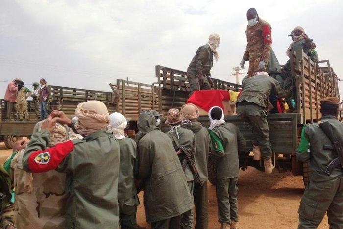 Soldiers load caskets at a funeral for victims of a suicide bomb attack at a camp in northern Gao housing former rebels and pro-government militia which killed some 77