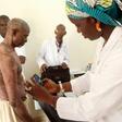 A doctor takes pictures of a man's skin condition for diagnosis through an online dermatology platform in Mali
