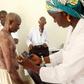 A doctor takes pictures of a man's skin condition for diagnosis through an online dermatology platform in Mali