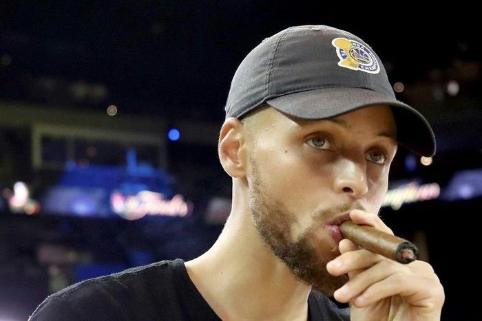Stephen Curry of the Golden State Warriors smokes a cigar after defeating the Cleveland Cavaliers in game five to win the 2017 NBA Finals, at ORACLE Arena in Oakland, California, on June 12