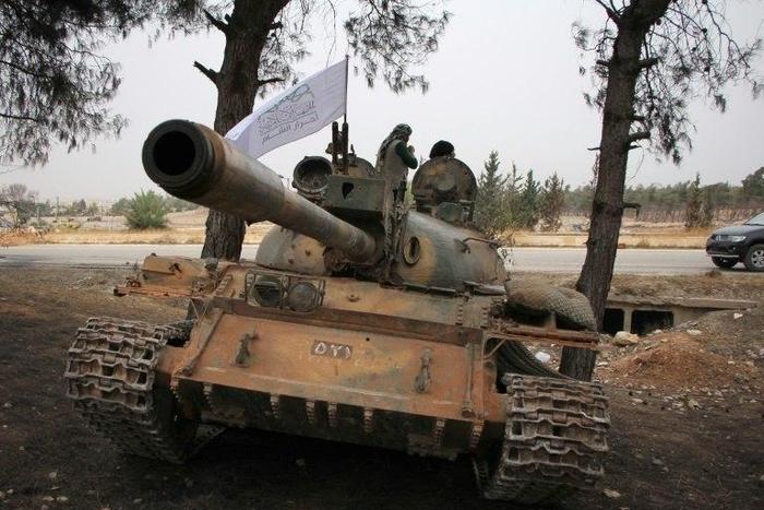 Syrian rebel fighters from the Jaish al-Fatah (or Army of Conquest) stand on a T-55 tank as they hold a position on the outskirts of Aleppo in October 2016