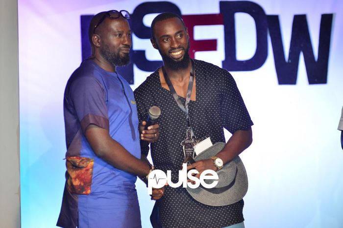 Kola Kuddus presents Hym Signage his award at NSDFW 2017