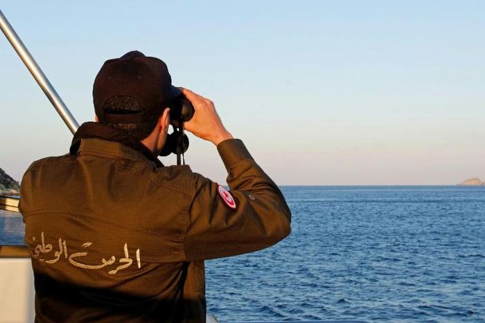 A Tunisian coast guard officer monitors the country's maritime borders during a patrol on March 30, 2017
