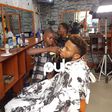 Lekan giving Pulse Tv's Chuey a haircut while Chris records them.