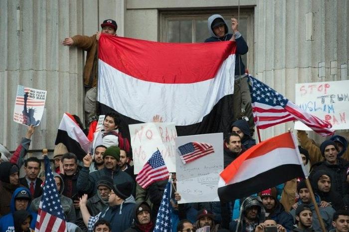 People rally with flags at Brooklyn Borough Hall as Yemeni bodega and grocery-stores shut down to protest US President Donald Trump's Executive Order banning immigrants and refugees from seven Muslim-majority countries on February 2, 2017 in New York