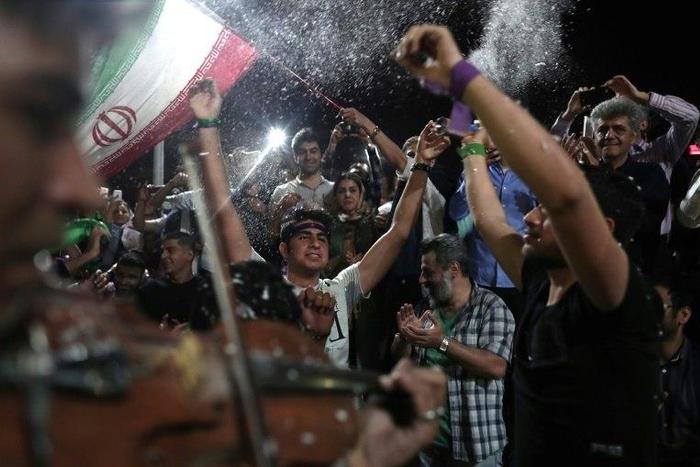 Supporters of newly re-elected Iranian President Hassan Rouhani dance during a gathering to celebrate his victory at the Vanak square in downtown Tehran on May 20, 2017