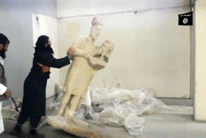 Image grab taken from a video released by the Media Office of the Nineveh branch of the Islamic State (IS) Group on February 26, 2015 allegedly showing an IS militant pushing a statue inside the Mosul museum
