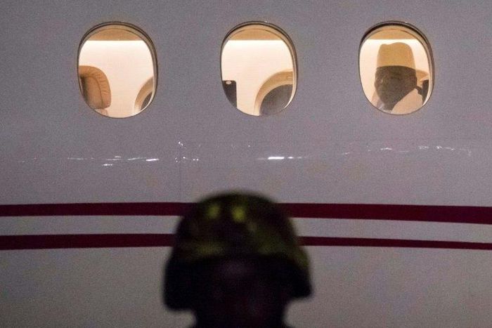 The Gambia's former president Yayha Jammeh, the country's leader for 22 years, looks out from the window from the plane at Banjul airport as he leaves the country on January 21, 2017