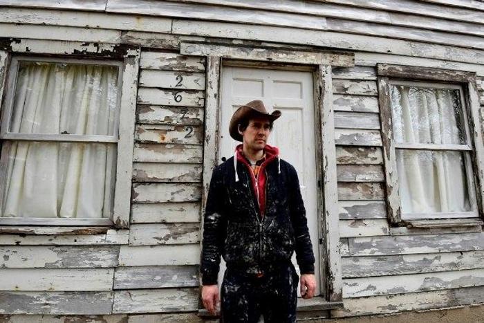 Artist Ryan Mendoza poses in front of Rosa Parks' house during which he helped rescue from Detroit and rebuilt it in his garden