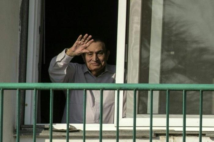 Former Egyptian president Hosni Mubarak waves to supporters from his room at the Maadi military hospital in Cairo on October 6, 2016