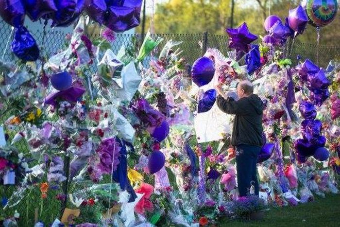A fan visits a memorial outside Paisley Park, the home and studio of Prince, in April, 2016 in Chanhassen, Minnesota