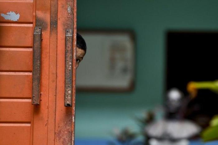 A Central American migrant child watches behind the main door of the Bethlehem Shelter in Tapachula, Chiapas state, Mexico