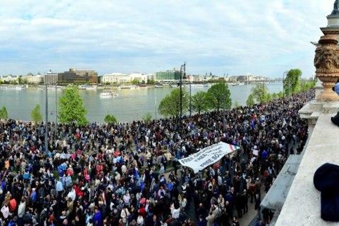 Tens of thousands demonstrated in Budapest against the controversial education legislation the day before it was signed, many chanting "Don't sign it, Janos!" and holding up placards reading "Veto!"