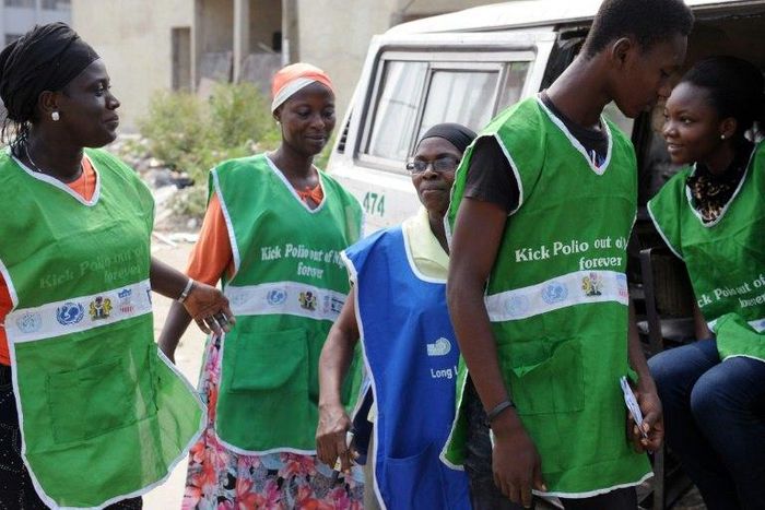 Health workers try to board a vehicle taking them to designated centres to immunise children.