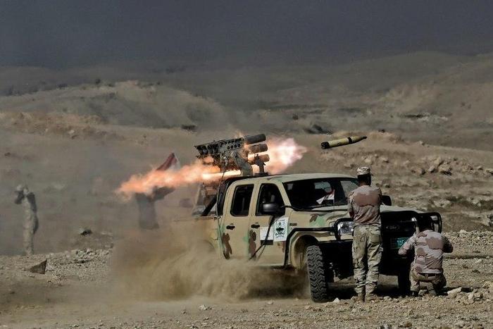Members of the Iraqi army's 9th Division fire a multiple rocket launcher from a hill in Talul al-Atshana, on the southwestern outskirts of Mosul, on February 27, 2017, during an offensive to retake the city from Islamic State (IS) group fighters