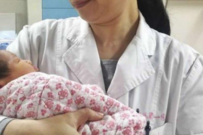 A doctor holds the healthy newborn boy at the First Affiliated Hospital of Sun Yat-sen University, in Guangdong.
