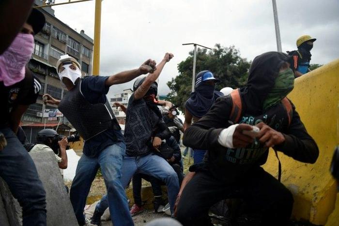 Demonstrators in Caracas hurl rocks at police during Venezuela's nationwide strike on Thursday