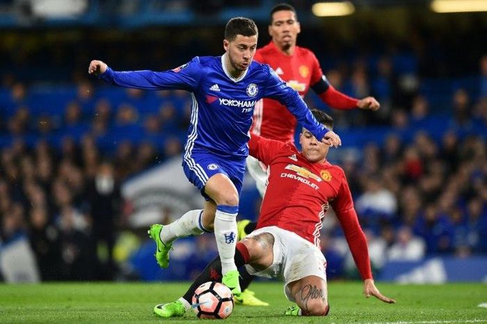 Chelsea midfielder Eden Hazard (L) is tackled by Manchester United defender Marcos Rojo during the FA Cup quarter-final at Stamford Bridge in west London on March 13, 2017