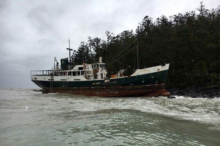 A vessel sits on the rocks after running aground near the Whitsunday Islands during Cyclone Debbie