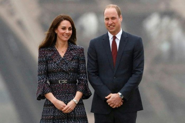 Britain's Prince William and his wife Kate pose in front of the Eiffel Tower during a visit to Paris on March 18, 2017. Six media representatives will go on trial Tuesday over the publication of Kate sunbathing topless in France