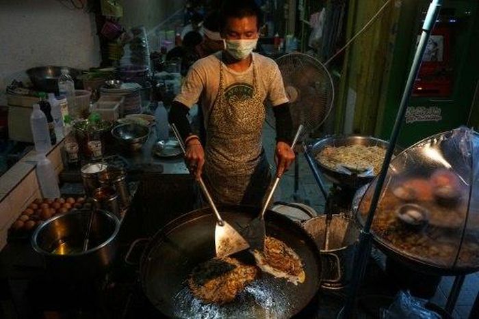 A man prepares food at a street stall in the Phrakanong district of Bangkok