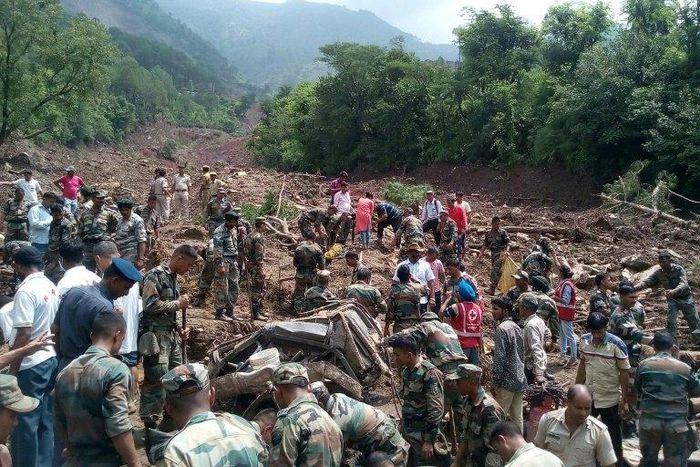 Rescuers look for survivors at the site of a landslide in Himachal Pradesh, northern India