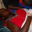 Olivia Nangozi on her hospital bed after her husband slit her neck