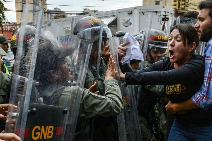 Venezuelan opposition deputy Amelia Belisario (2nd-R) scuffles with National Guard during a protest in front of the Supreme Court in Caracas