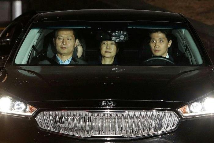 Ousted South Korean President Park Geun-hye (C), leaves the prosecutors' office in a car as she is transferred to a detention house early on March 31, 2017 in Seoul