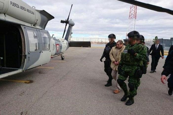 Joaquin Guzman aka "El Chapo" (C) is escorted by Mexican police during his extradition to the United States on January 19, 2017, in Ciudad Juarez