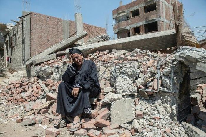 Egyptian Shoukran Rashwan, 75, sits on the rubble of her demolished house on Cairo's Warraq island on July 20, 2017