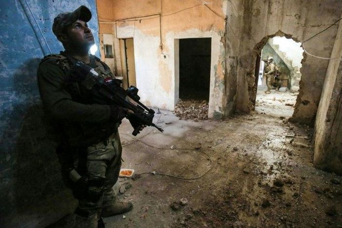 Iraqi forces advance in a house in the Old City in west Mosul on March 17, 2017