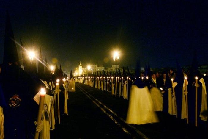 Penitents of 'La Esperanza de Triana' brotherhood parade during a Good Friday procession in Seville