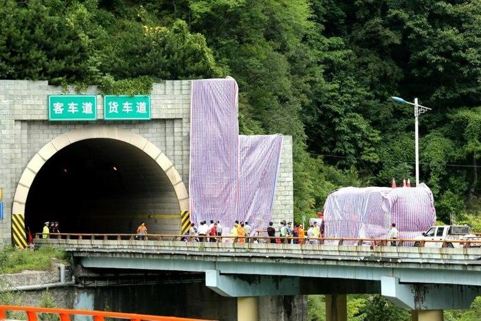 The bus appears to have struck a wall just outside the mouth of the tunnel in Ankang, northern China, with authorities placing a long tarp over to the right of the entrance, with another cover concealing the coach