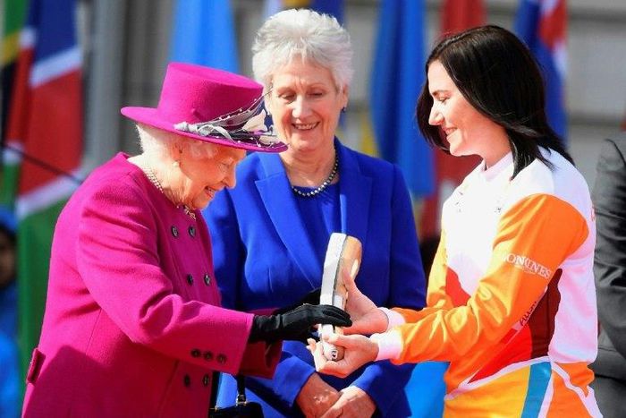 Retired cyclist Anna Meares (R) from Australia receives the baton from Britain's Queen Elizabeth II during the launch of the Queen's baton relay for the 2018 Commonwealth Games at Buckingham Palace in London, March 13, 2017