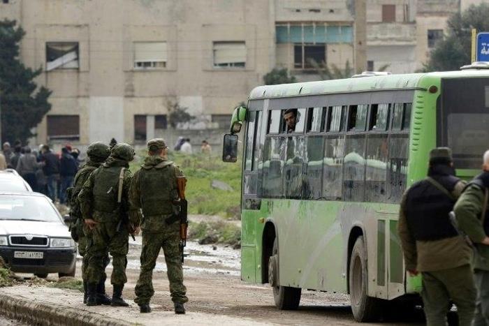 Russian military police stand guard during the evacuation of the last rebel-held district of Syria's Homs on March 18, 2017