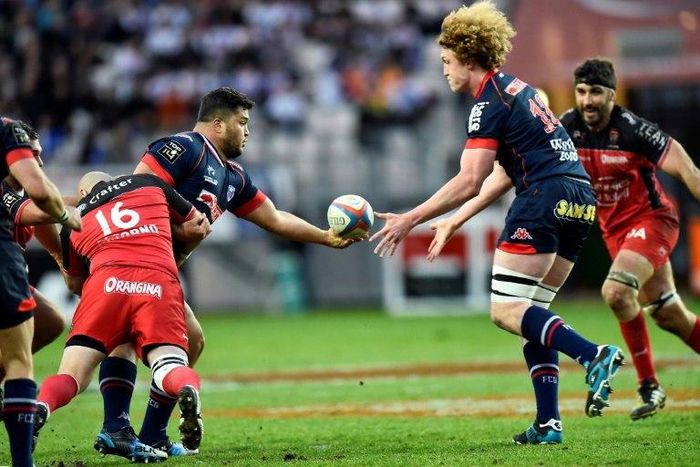 Grenoble's prop Ali Oz (L) passes the ball to lock Thomas Jolmes on March 19, 2016