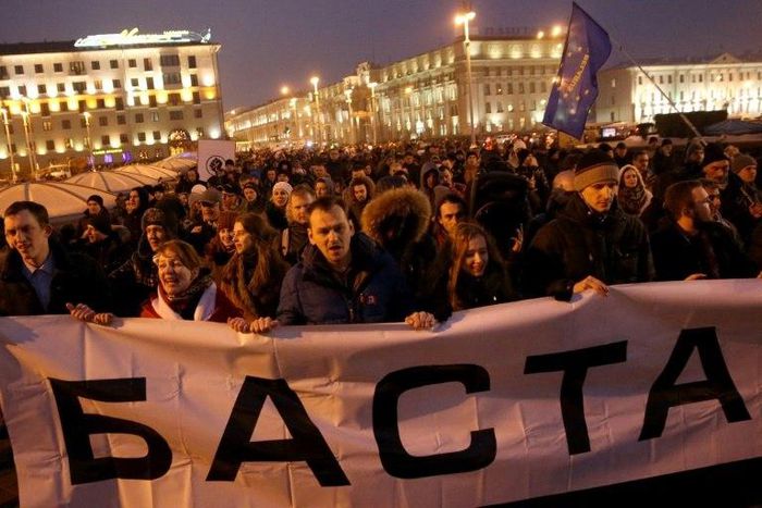 People carry a banner reading "Stop" during a rally called the "March of Infuriated Belarusians" against a Soviet-style "tax on spongers" in Minsk, on February 17, 2017, with biggest round of opposition protests yet planned for March 25, 2017