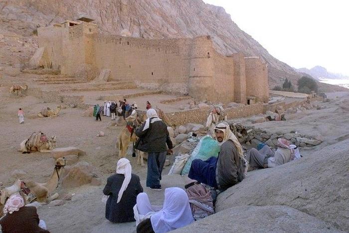 Egyptian Bedouins wait for tourists with their camels outside the walls of St Catherine monastery in the Sinai desert