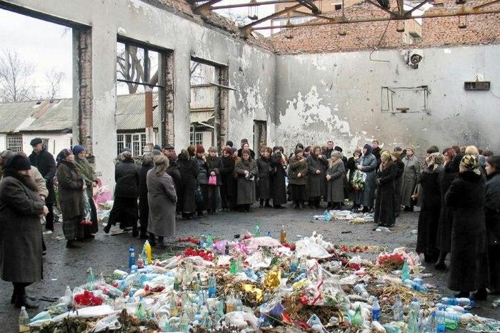 Friends and relatives of victims killed in the 2004 Beslan school hostage massacre gather on March 3, 2005 in the remains of the school in North Ossetia for a minute's silence to commemorate the six-month anniversary of the tragedy