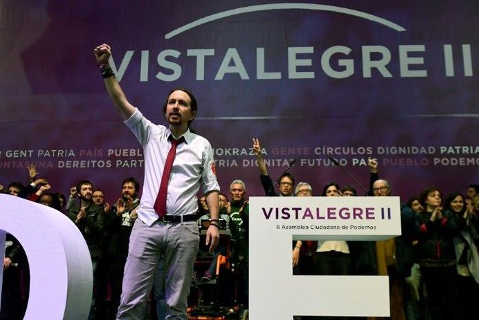 Pablo Iglesias (L), leader of left-wing party Podemos, raises his fist during the second day of the party congress at Vistalegre bullring in Madrid on February 12, 2017 that saw him re-elected as general secretary