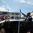 Former Haitian president Jean-Bertrand Aristide greets supporters in Port-au-Prince in a rare public outing to testify in a money laundering case