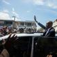 Former Haitian president Jean-Bertrand Aristide greets supporters in Port-au-Prince in a rare public outing to testify in a money laundering case