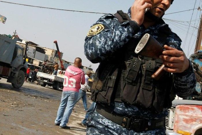 An Iraqi policeman guards the site where a car bomb exploded in an industrial area of south Baghdad on February 14, 2017, killing at least four people